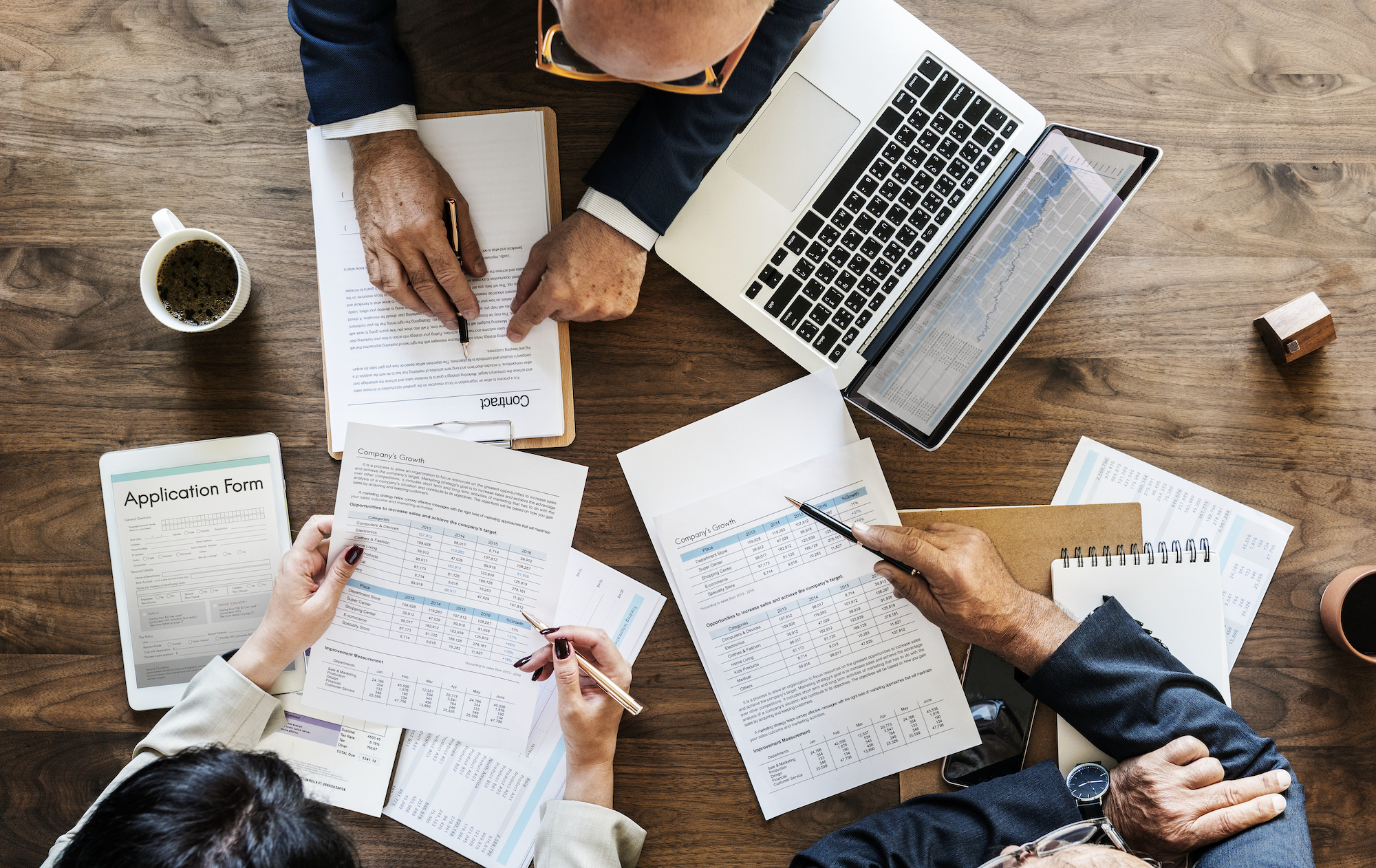 aerial view of business people in office sat over a pile of documents